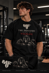 Male fitness model wearing MUSCLE FACTORY brand a black oversized MF gym T-shirt featuring ‘The Industry Is Full of Wildlife’ wolf, rat, and snake graphic, with close-up details highlighting premium cotton, oversized fit, and quality finish.
